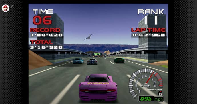 A purple racing car in the middle of a race. Three cars are leading as a light aircraft dips down on the horizon. There is a speedometer and other UI information around the peripherally of the screen.