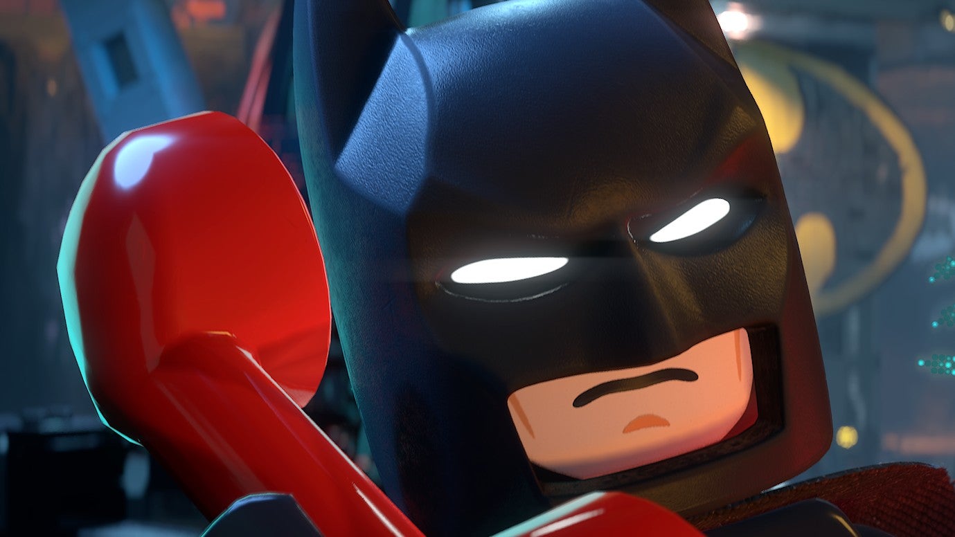 Screenshot z Lego Batman: Odkaz Temného Rytíře, kde Batman telefonuje v jeho Batcave