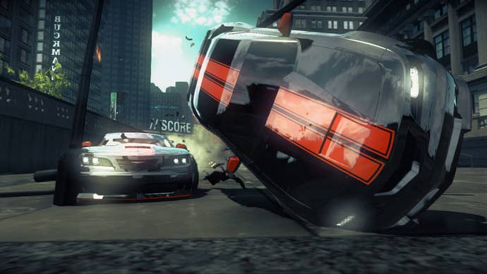 Screenshot from Ridge Racer Unbound showing a two cars on the road with the one closest to the camera toppling over onto its roof