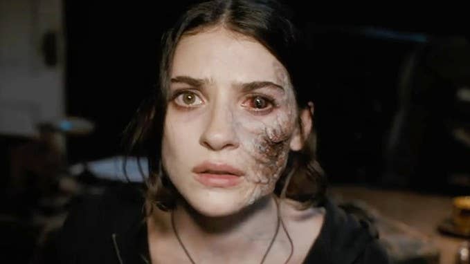 Screenshot from Until Dawn film showing a female character with a bloodshot eye and painful looking distortion down the side of her face