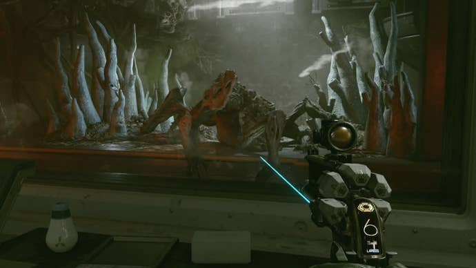 cropped first person view of a terrormorph in a windowed holding area with the characters pistol pointed at it