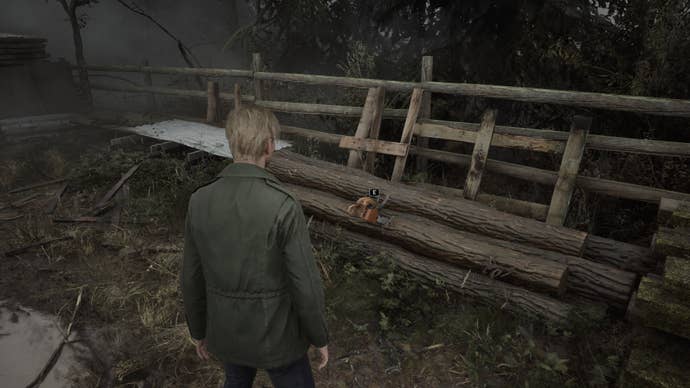 James looks at the chainsaw wedged into some logs in the Silent Hill 2 remake