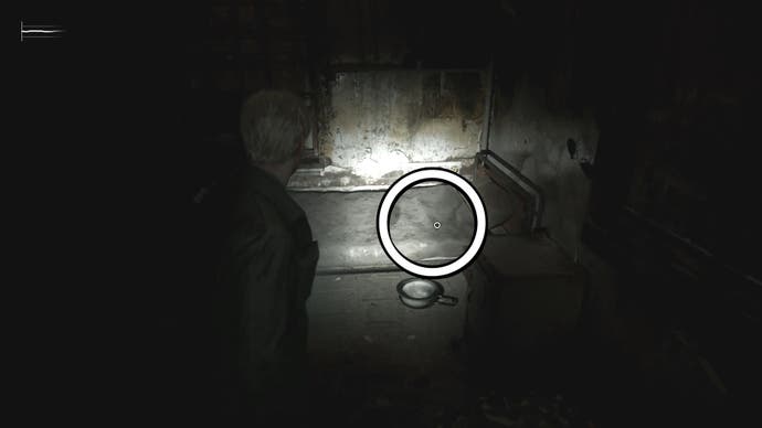 A white circle showing the Filfthy Bracelet under the bedspreads in Silent Hill 2.