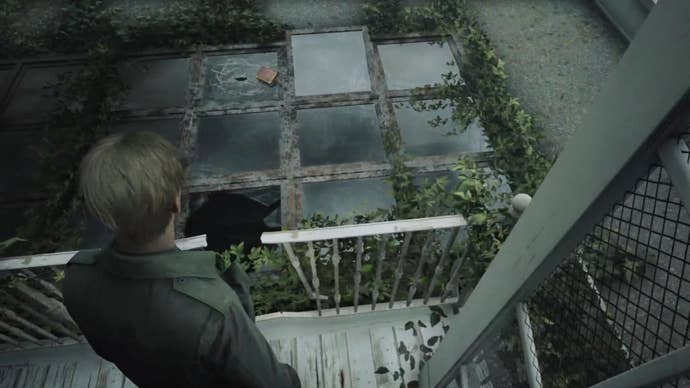 James looks at a book that is laying on a broken skylight in Lake View Hotel in the Silent Hill 2 remake