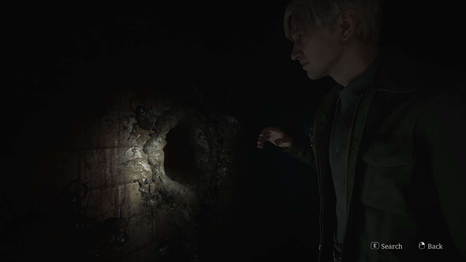 James puts his hand into a hole in the wall in Toluca Prison in the Silent Hill 2 remake - 8