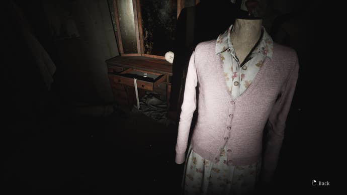 James looks at Mary's dress, which holds a flashlight, in the Wood Side Apartments in the Silent Hill 2 remake