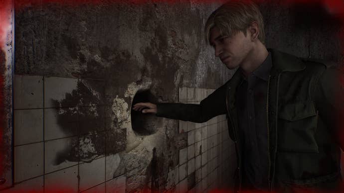 James nervously prepares to stick his hand in a mysterious hole in the wall the Silent Hill 2 remake.