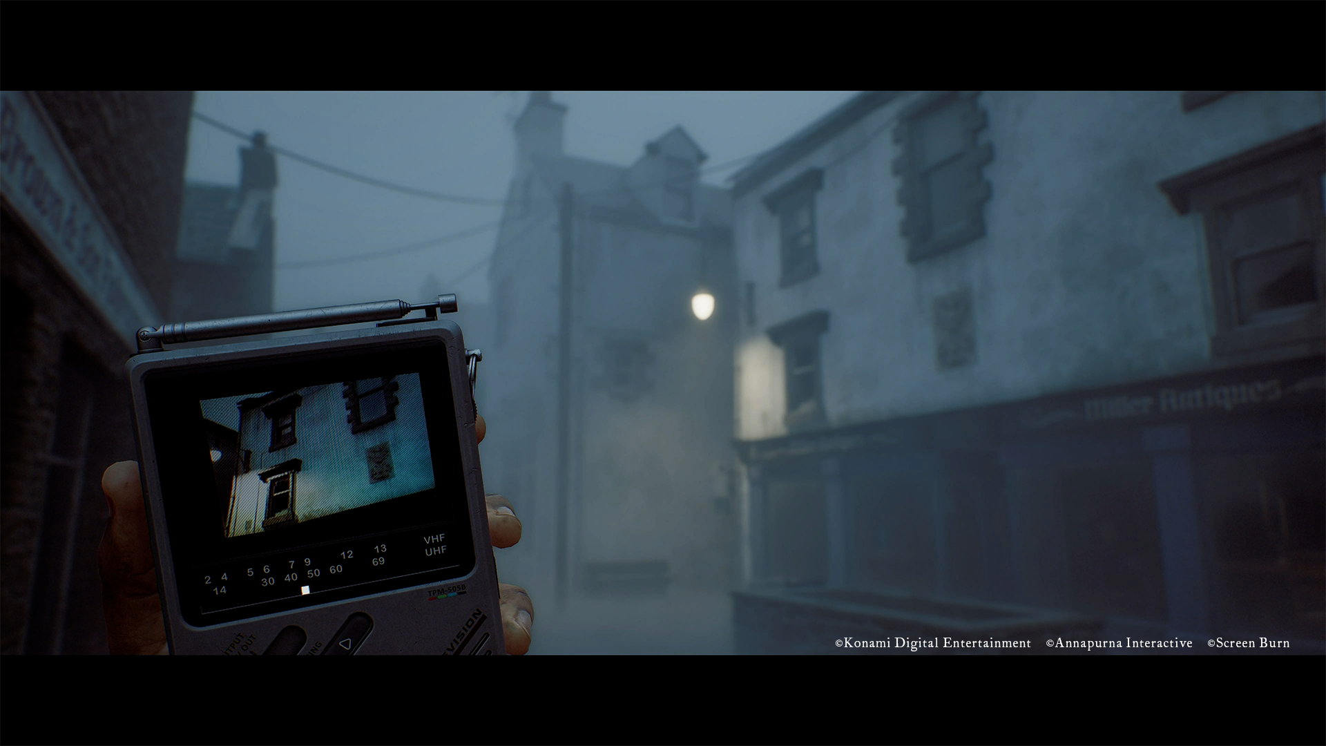 Simon walks towards a house, indicated by the image on his portable CRTV, in Silent Hill: Townfall.