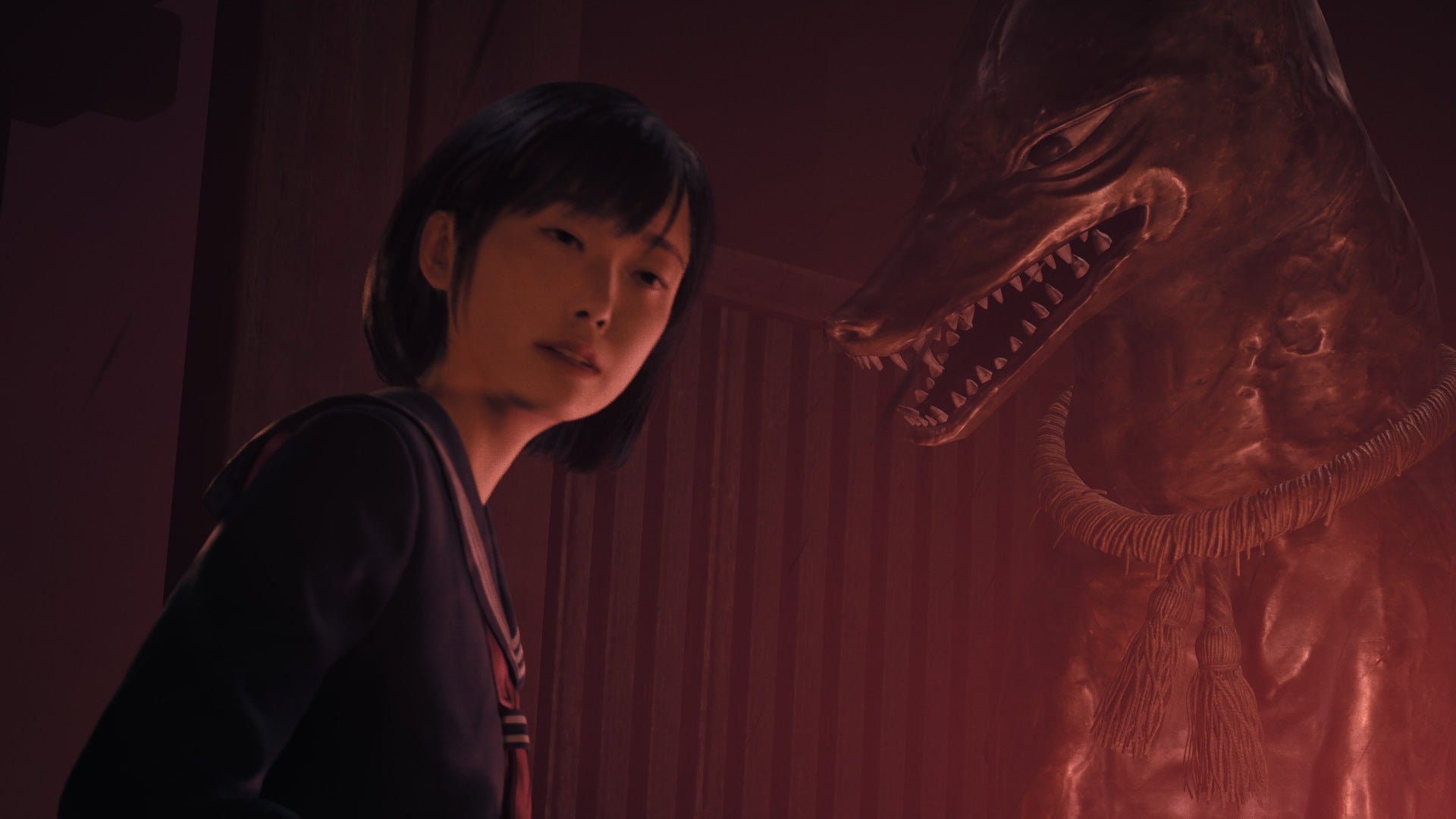 Hinako can be seen looking at a smiling dog statue on Shrine Path in Silent Hill f