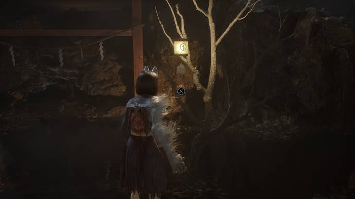 Hinako looks at a bell hanging from a tree with a tree symbol on it in Silent Hill f