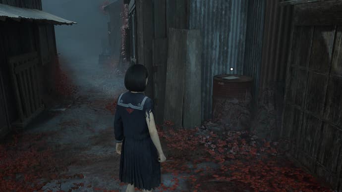 Hinako looks at the third Research Journal Photo on an oil drum in Silent Hill f
