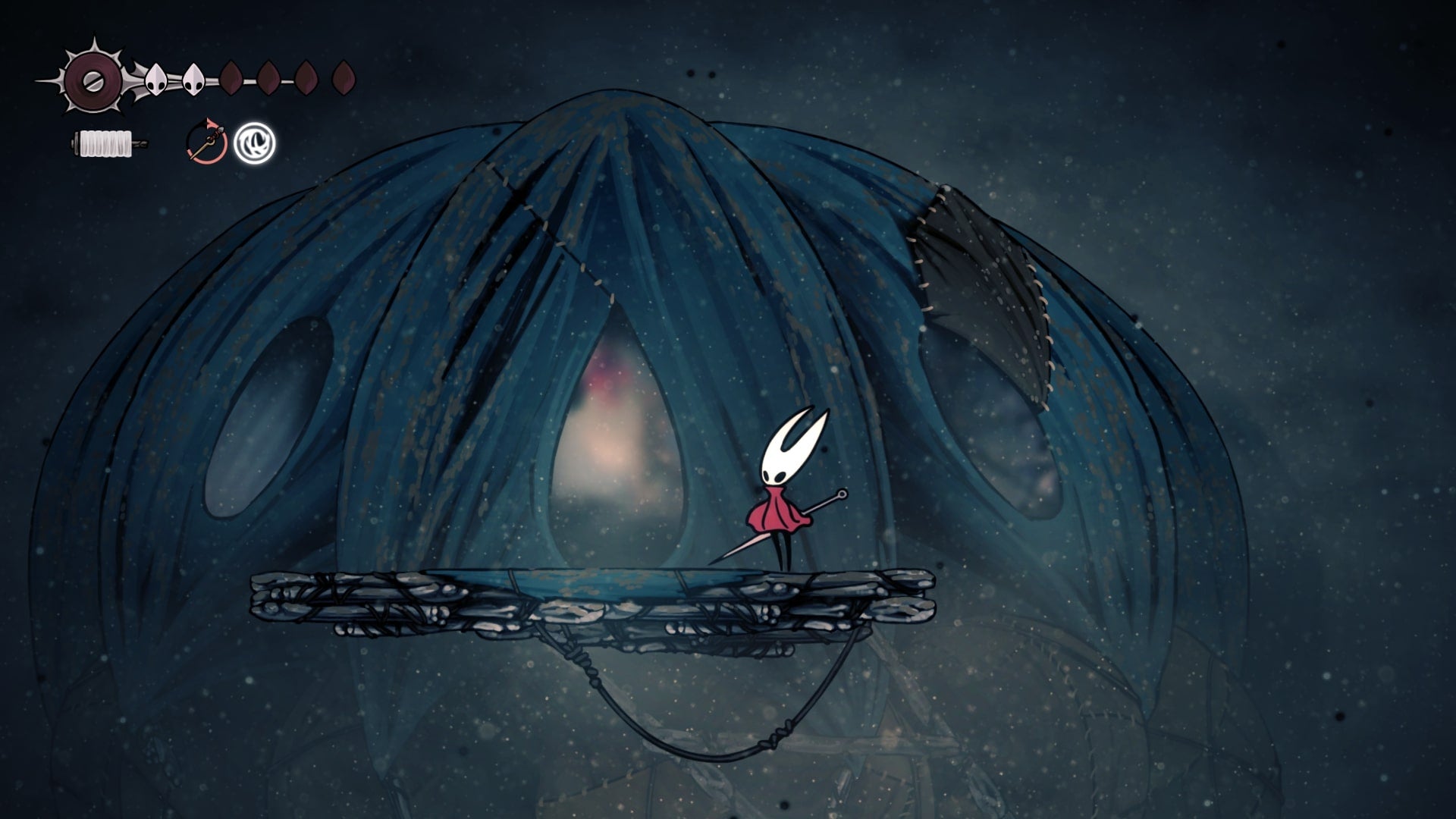 Hornet stands outside of the Pinstress' Tent in Blasted Steps in Hollow Knight: Silksong