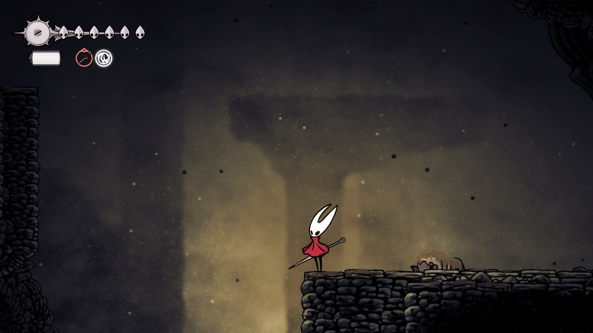 Hornet stands on a stone platform facing a wall in Blasted Steps in Hollow Knight: Silksong