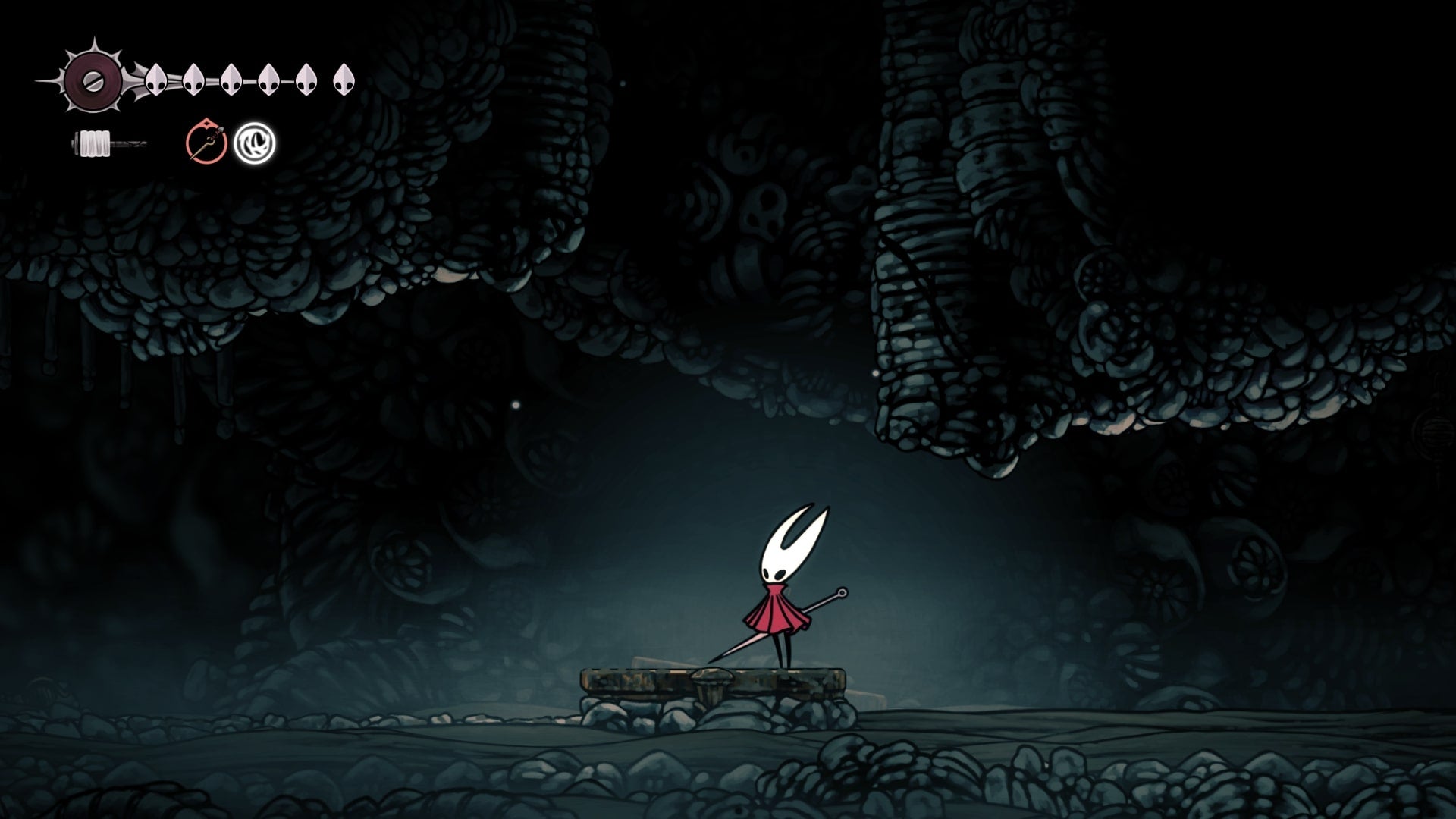 Hornet stands on a platform beneath a passageway in Blasted Steps in Hollow Knight: Silksong