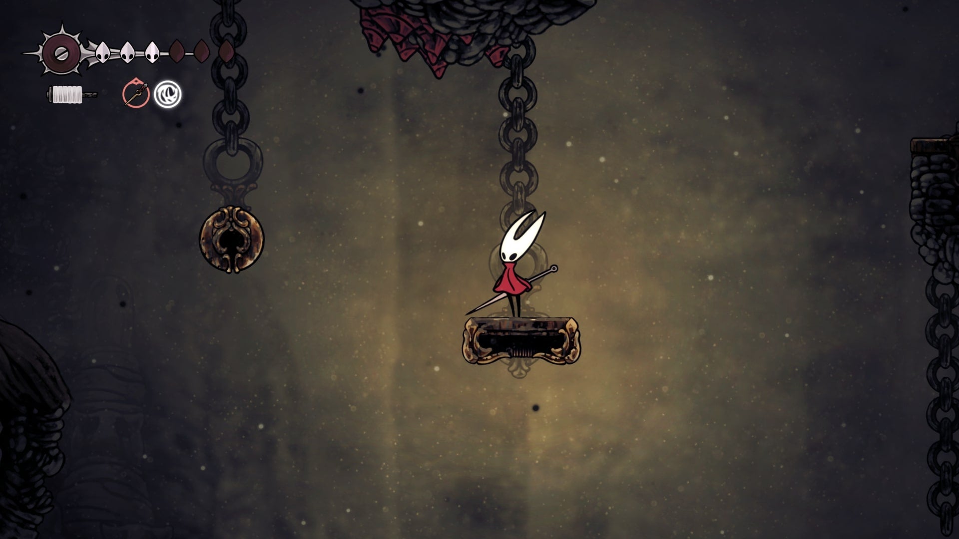 Hornet stands on a golden platform beside a bell in Blasted Steps in Hollow Knight: Silksong