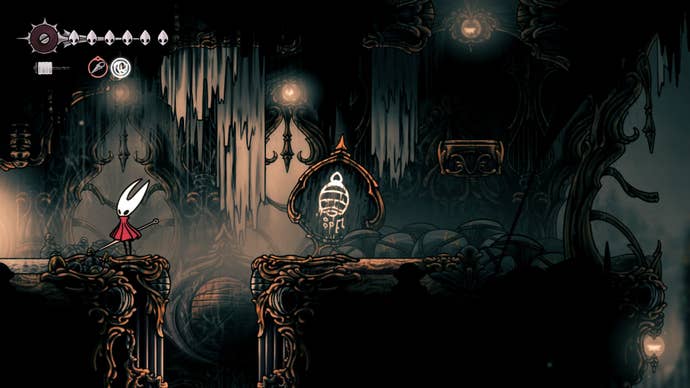 Hornet stands by an exit beside a Ventrica sign in Choral Chambers in Hollow Knight: Silksong