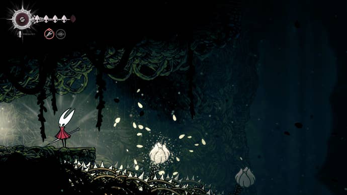 Hornet stands on a ledge beside some white flowerbuds, above spikes, that she can pogo off of in Shellwood in Hollow Knight: Silksong