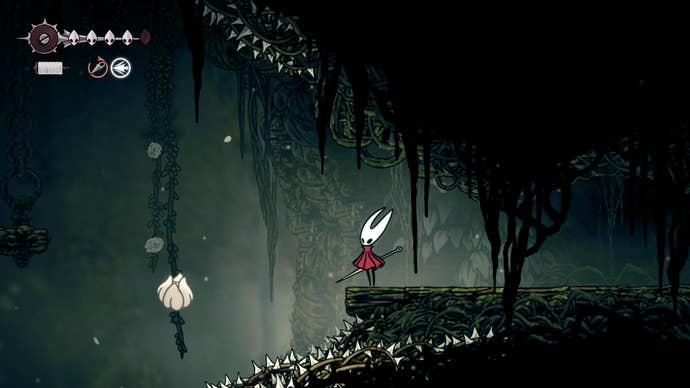 Hornet stands on a ledge beside a white flowerbud she can pogo off of in Shellwood in Hollow Knight: Silksong