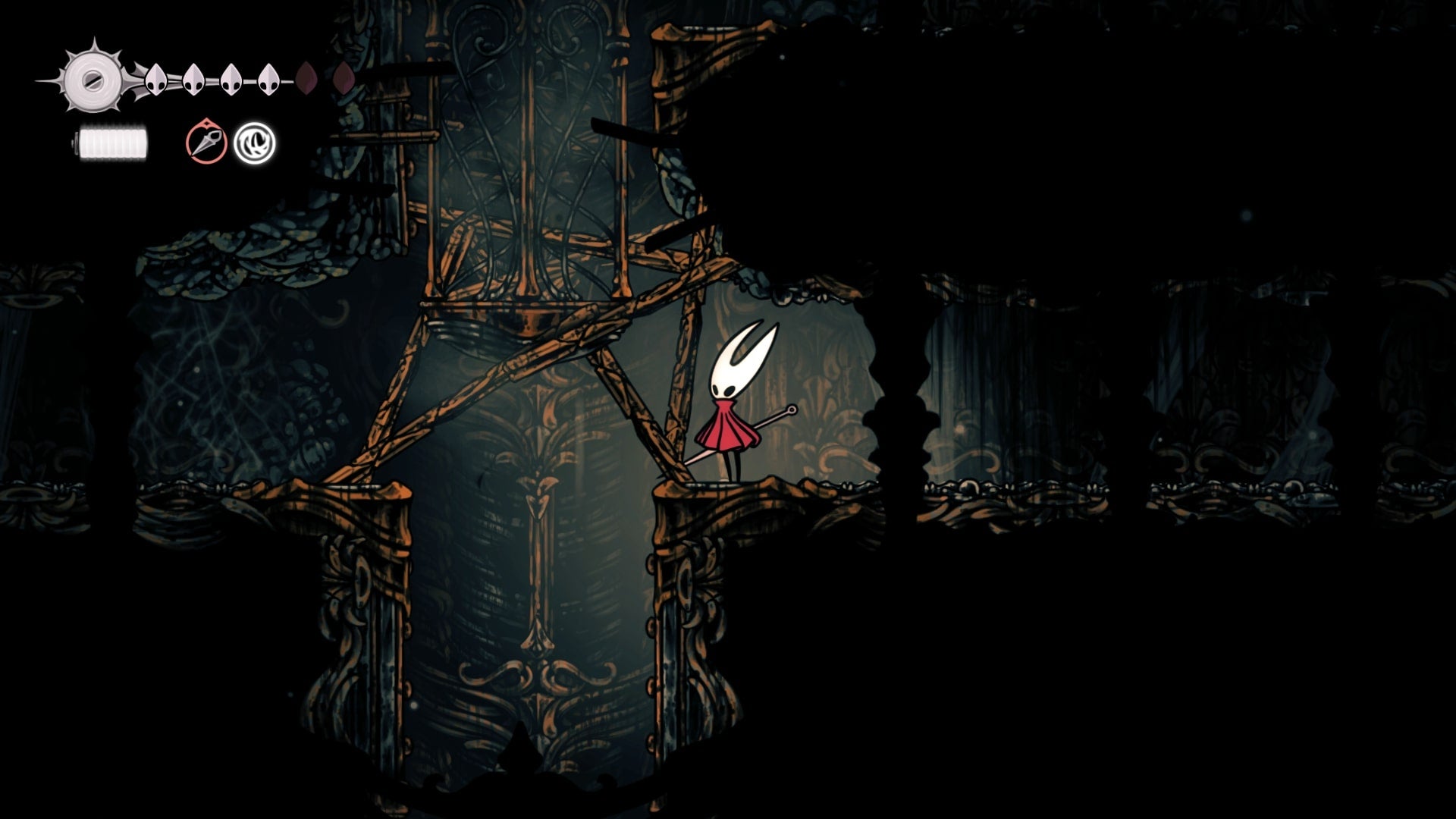 Hornet stands beside a breakable wooden barricade in the Exhaust Organ in Hollow Knight: Silksong