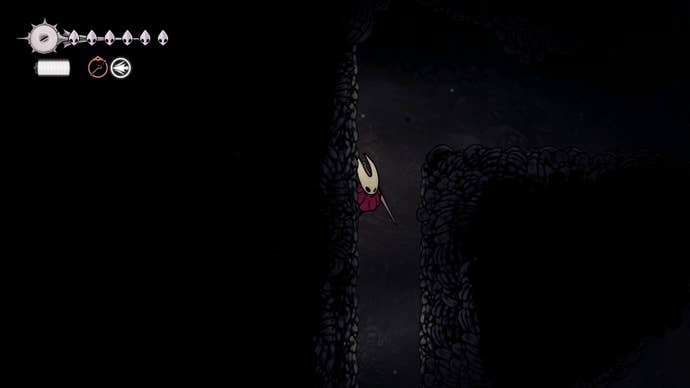 Hornet climbs up a wall using Cling Grip in Blasted Steps in Hollow Knight: Silksong