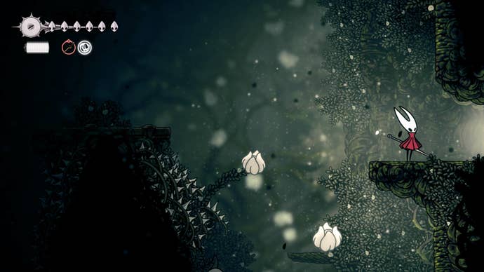 Hornet stands beside an exit near some flowerbuds and spike traps in Shellwood in Hollow Knight: Silksong