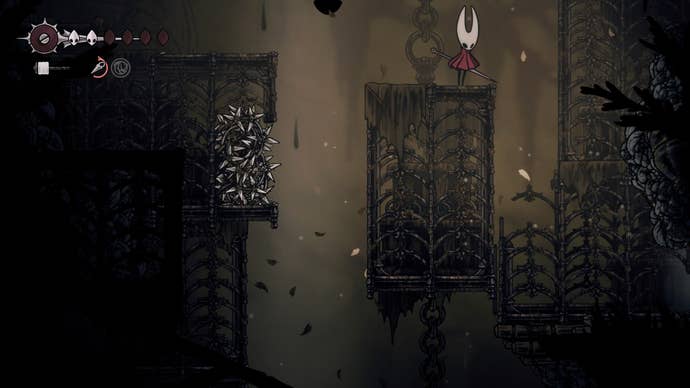 Hornet looks down at a broken cage that leads to an exit in Sinner's Road in Hollow Knight: Silksong