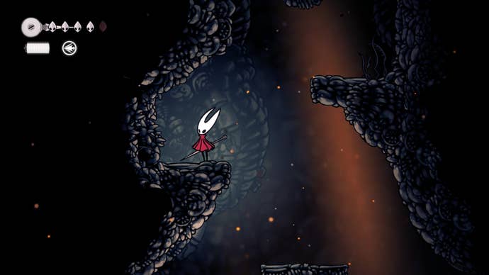 Hornet stands on a ledge with a secret passage to her left in The Marrow in Hollow Knight: Silksong