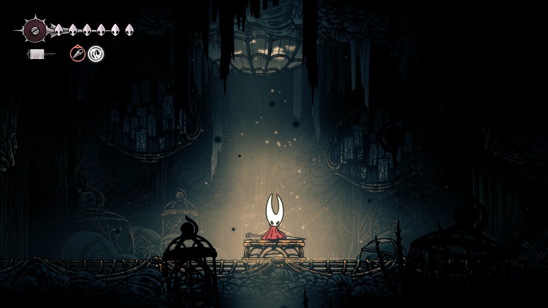 Hornet rests at a Bench in The Slab in Hollow Knight: Silksong