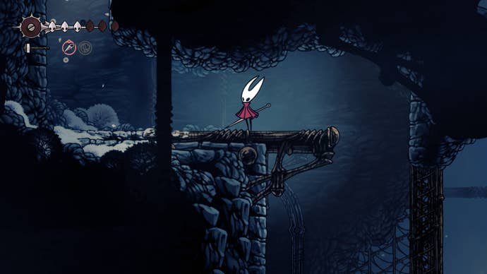 Hornet stands by an exit into Mount Fay in The Slab in Hollow Knight: Silksong