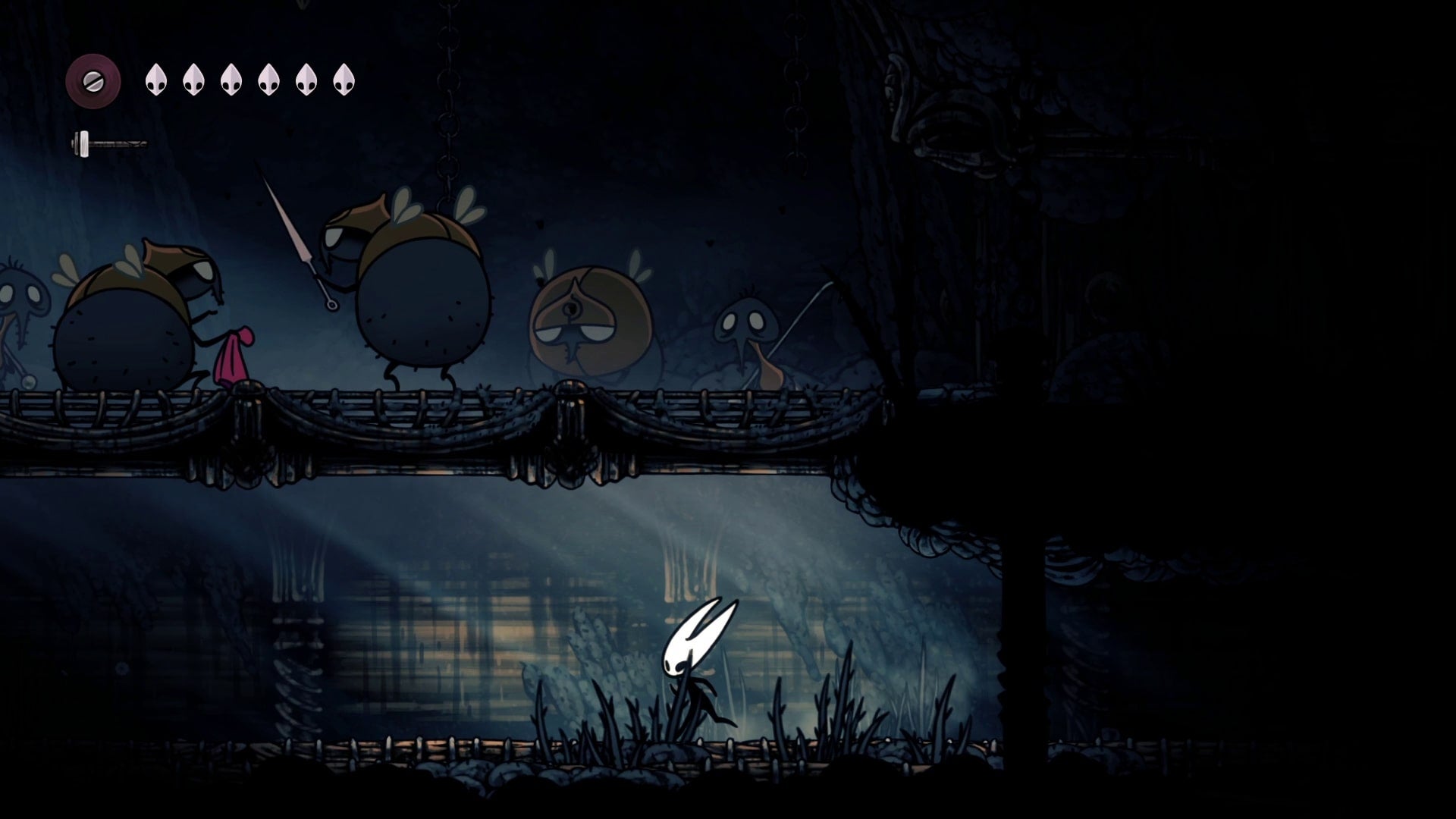 Hornet looks up at a room full of enemies who have her gear in The Slab in Hollow Knight: Silksong