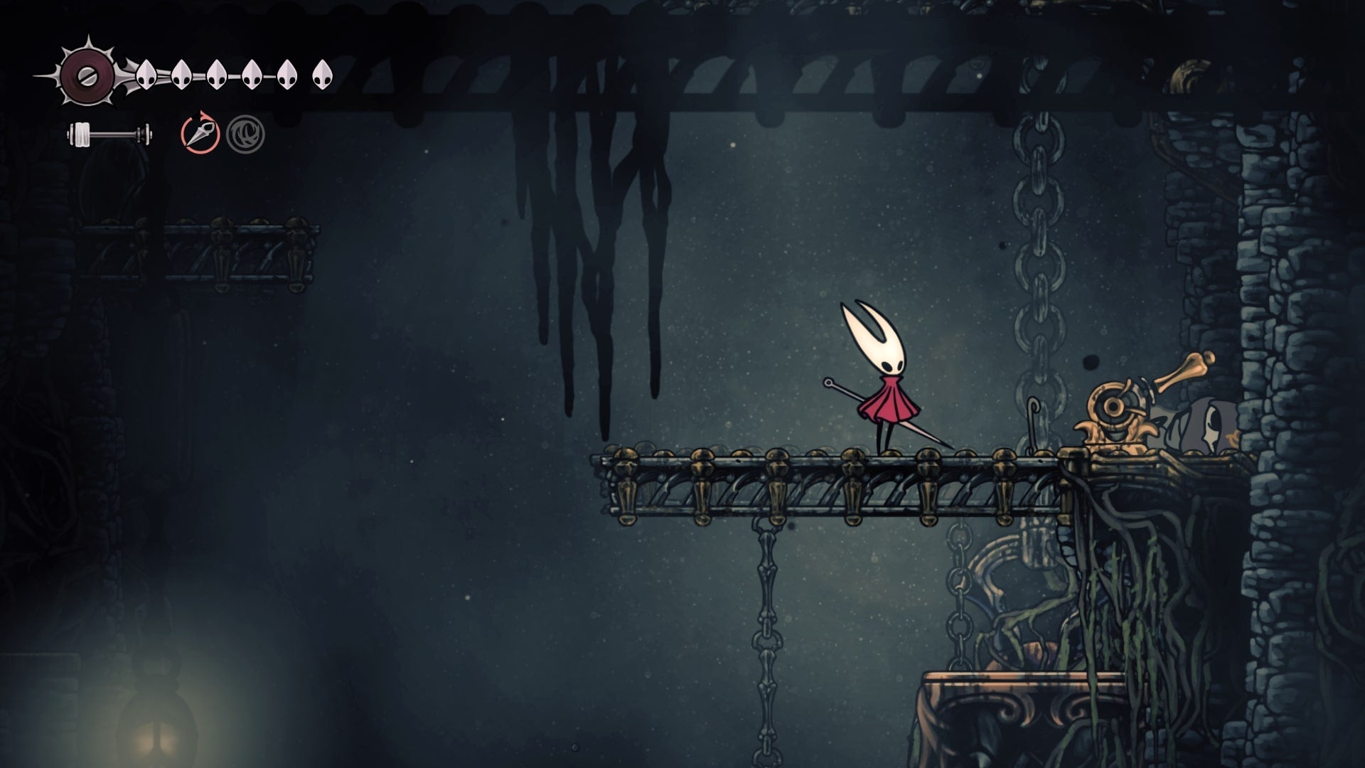 Hornet stands beside a lever in the Underworks in Hollow Knight: Silksong