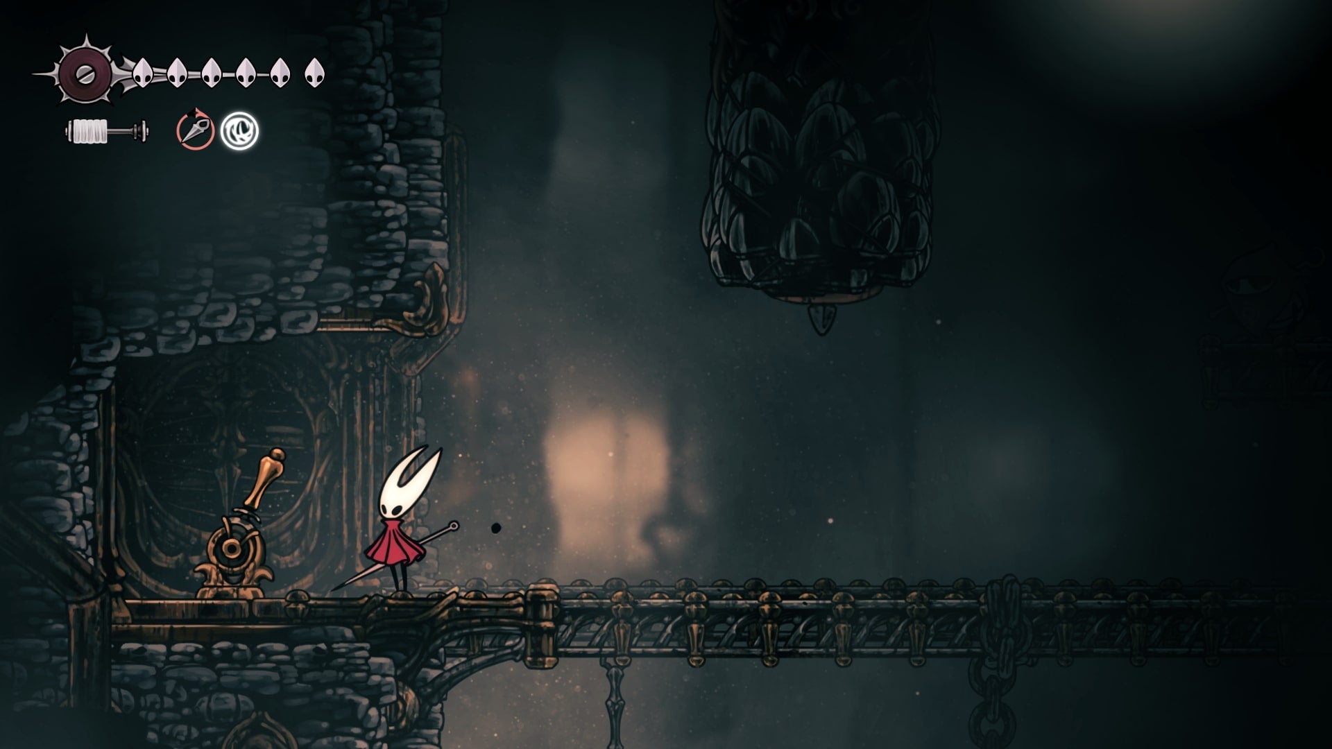 Hornet stands beside a lever in the Underworks in Hollow Knight: Silksong