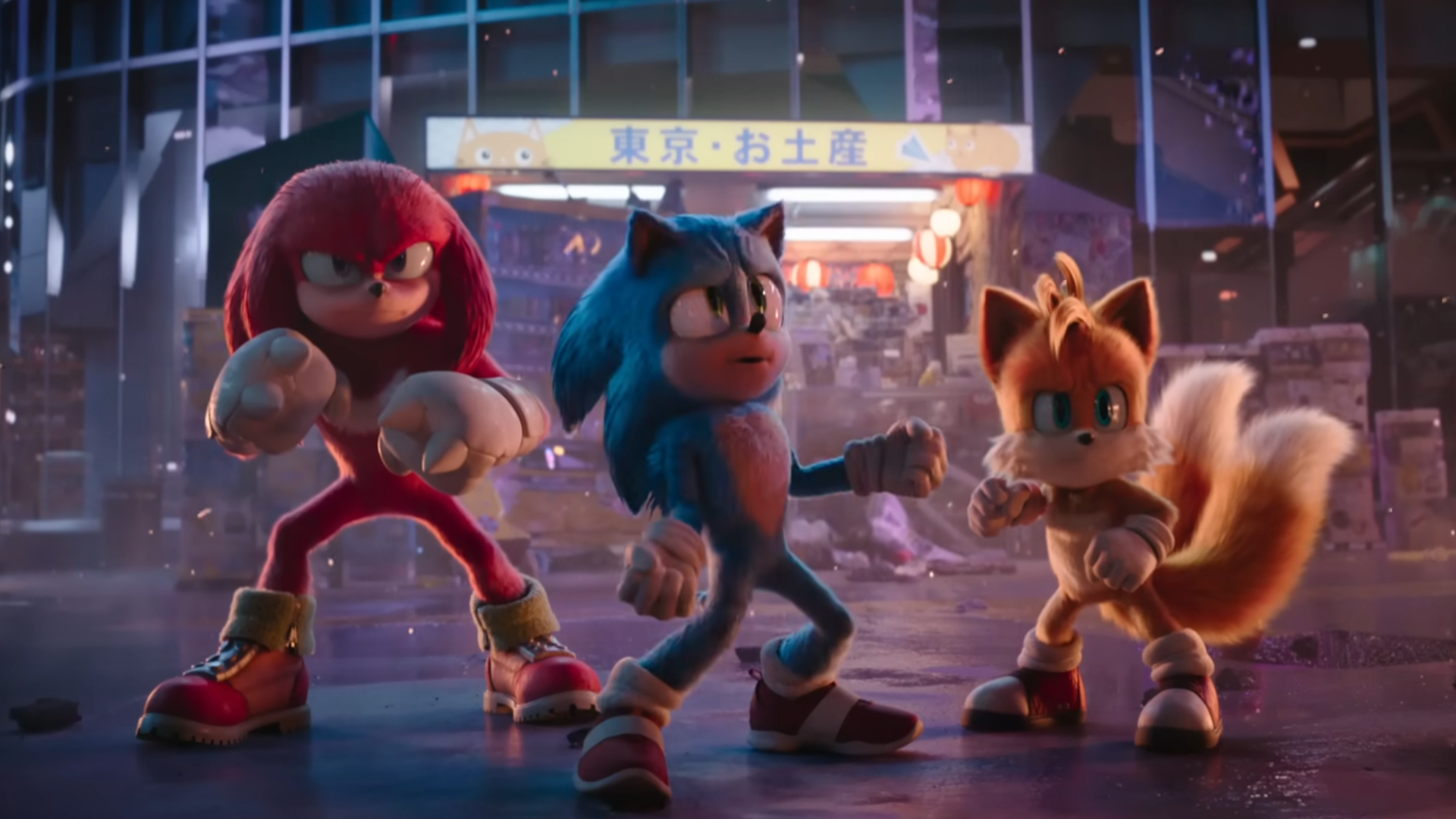 Sonic 3 film trailer screenshot showing Knuckles Sonic and Tails posing in a Tokyo street