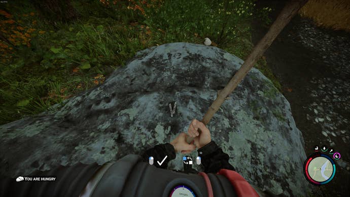 The player looks down at the marker on the floor where sticks will be placed in Sons of the Forest