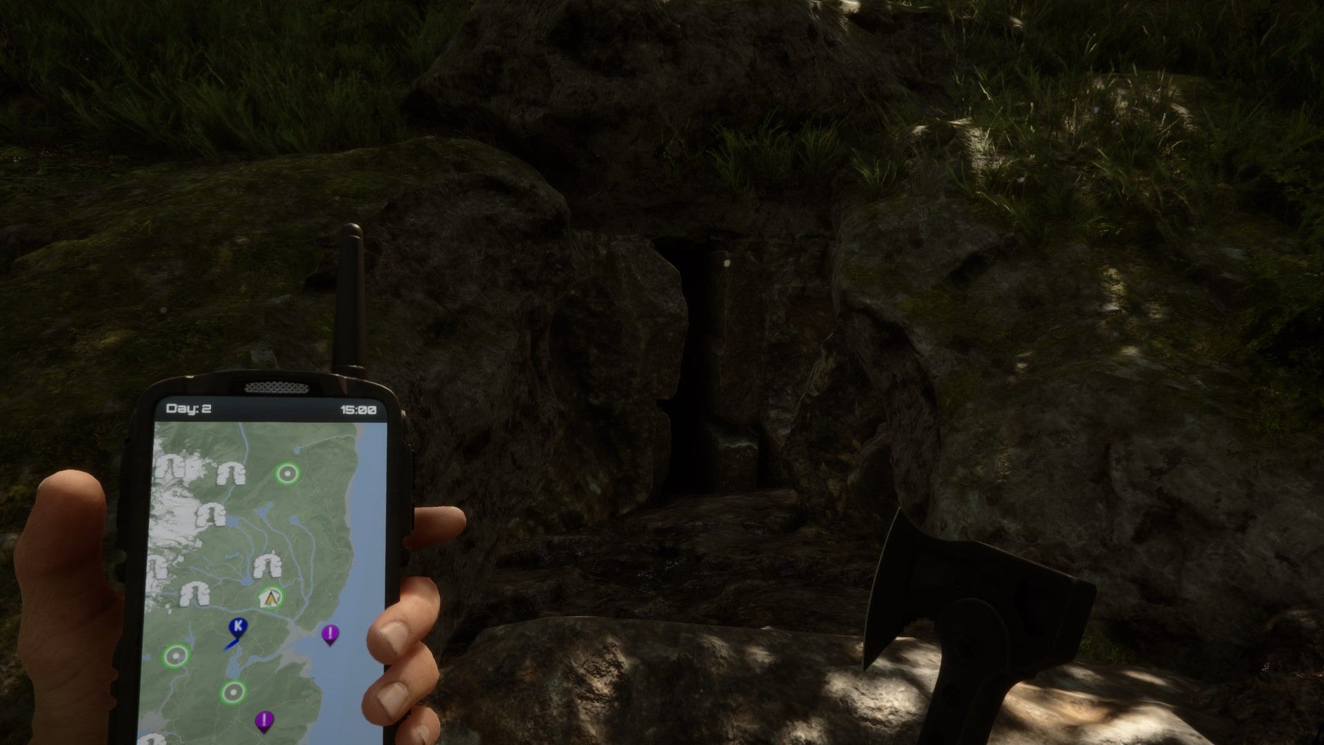 A player stares at a dark cave entrance while holding a GPS and an axe in Sons of the Forest. - 6