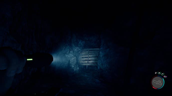 The player faces a barred opening in a cave in Sons of the Forest
