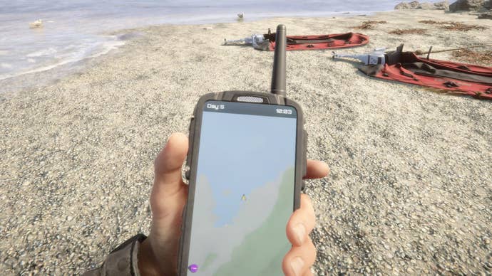 A player holds their GPS on the beach in Sons Of The Forest.