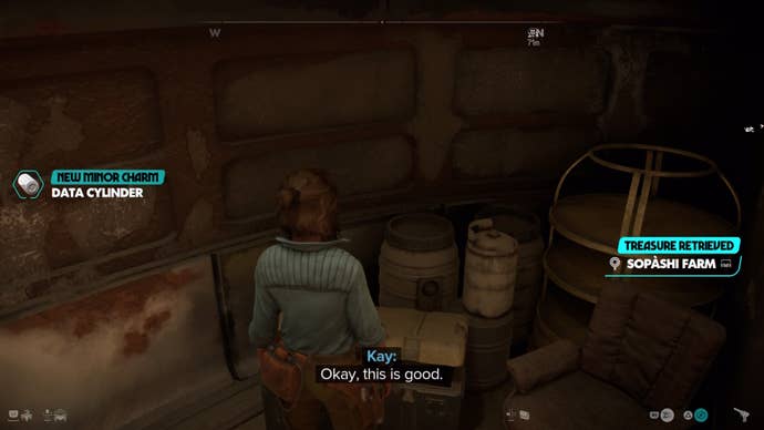 Kay looking at a container with the Data Cylinder Minor Charm reward text displayed on the left of the screen.
