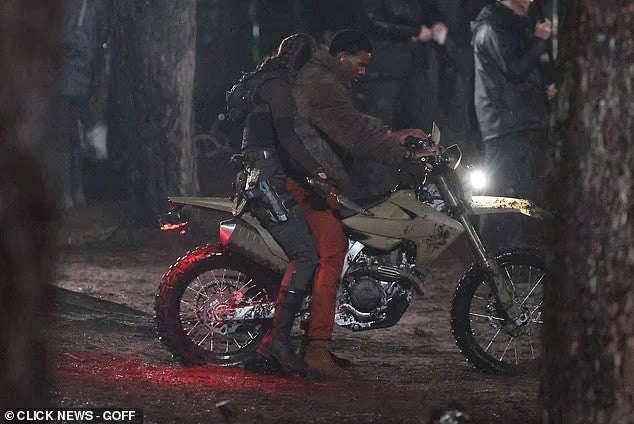 Sophie Turner and Martin Bobb-Semple on set of Tomb Raider sitting on the back of a motorcycle