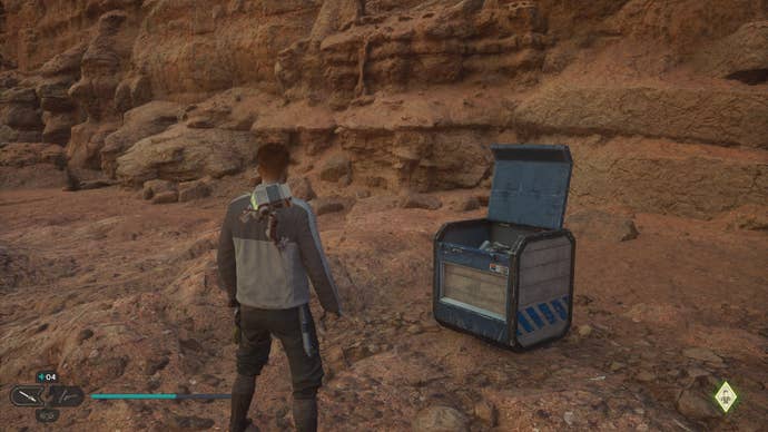 Star Wars Jedi Survivor screenshot showing Cal stood near an open chest on a sandy ledge.