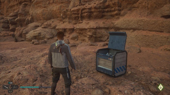 Star Wars Jedi Survivor screenshot showing Cal stood near an open chest on a sandy ledge.