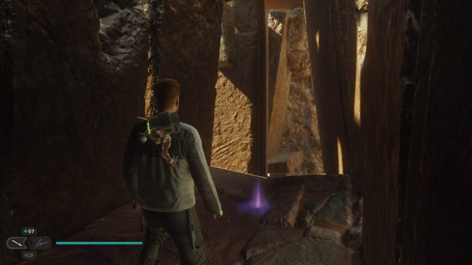 Star Wars Jedi Survivor screenshot showing Cal stood on a dark sandy ledge, near a purple Essence on the floor.