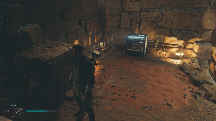 Star Wars Jedi Survivor screenshot showing Cal in a sandy cave staring at a chest.