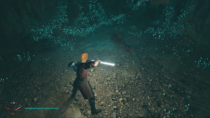 Star Wars Jedi Survivor screenshot showing Cal stood near a glistening Datadisc in a dark cave.