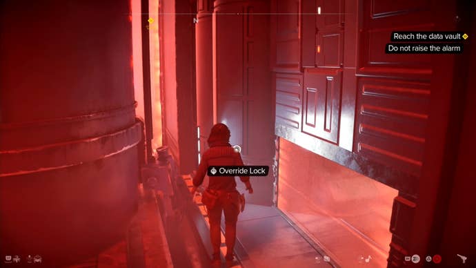 Kay crouched and looking at a lock override in a red-tinted room in Star Wars Outlaws.