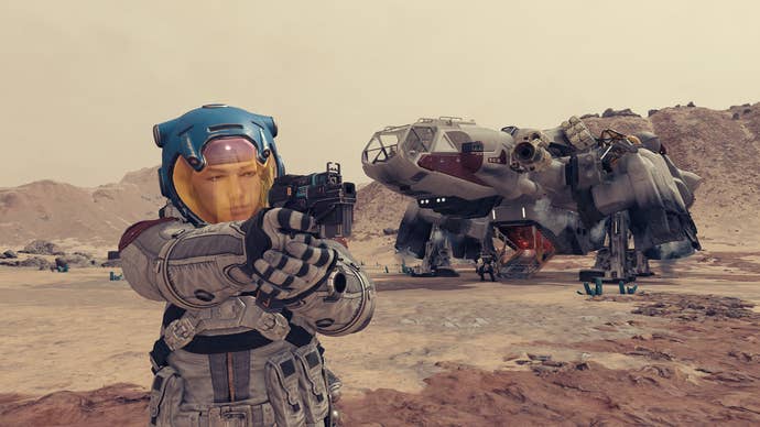 A spacesuit-clad Starfield protag aims a pistol in front of the Frontier, which has landed nearby.