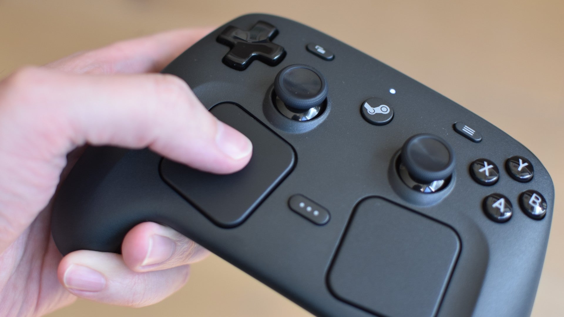 Thumbing the left trackpad on the new Steam Controller.