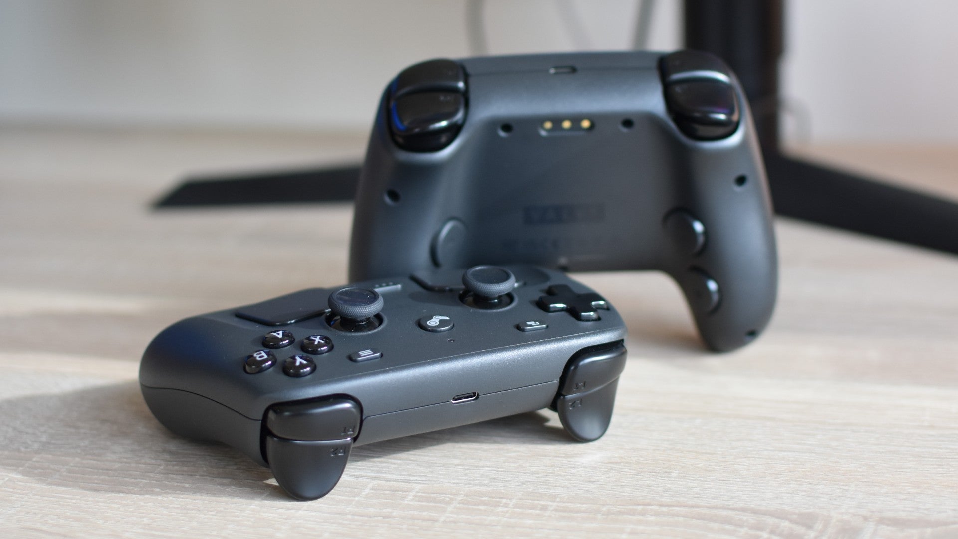 Two Steam Controllers on a desk.