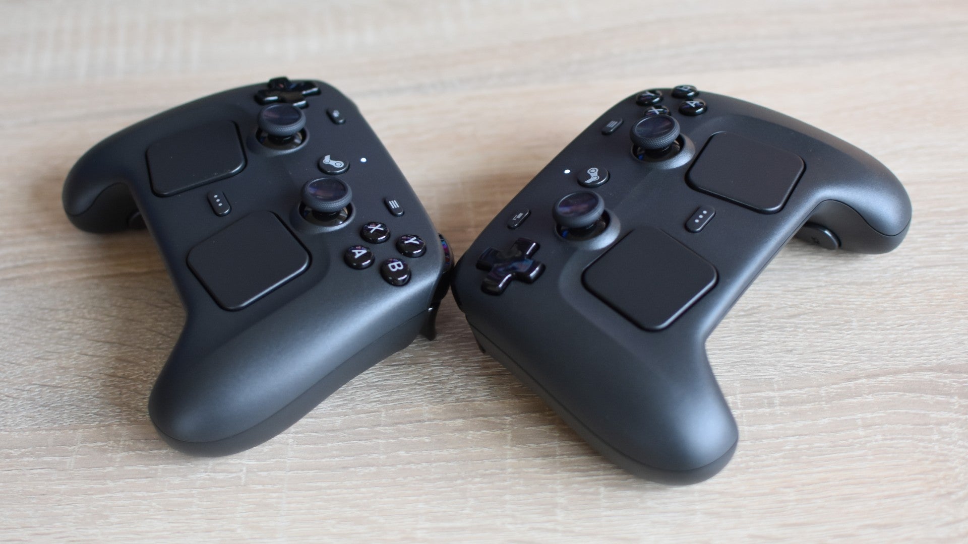 Two Steam Controllers on a desk.