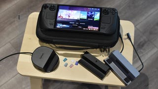 A Steam Deck OLED surrounded by various Steam Deck accessories, including a case, multiple docking stands, and several microSD cards.